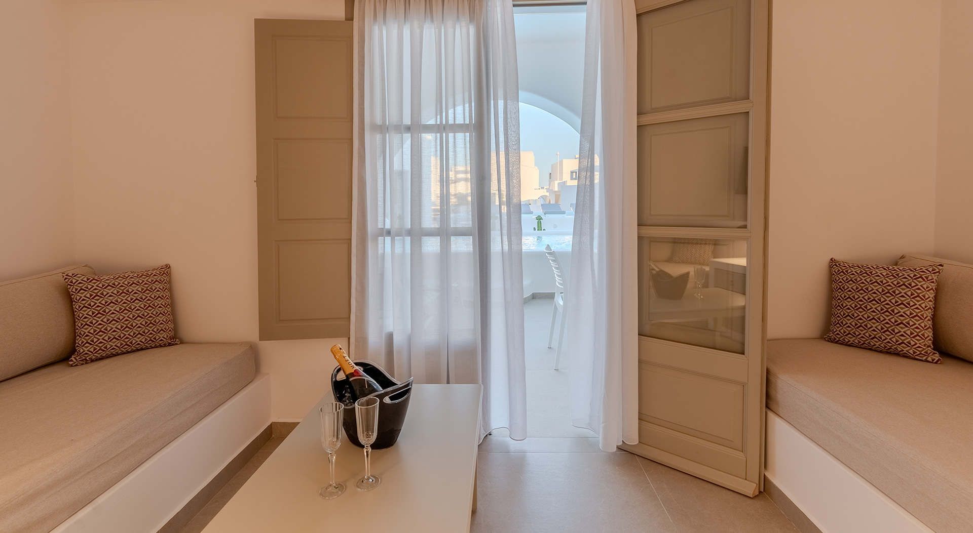 Lounge area opening onto the private pool terrace of the Signature Open Plan Suite at Antoperla Adults Only Santorini Hotel