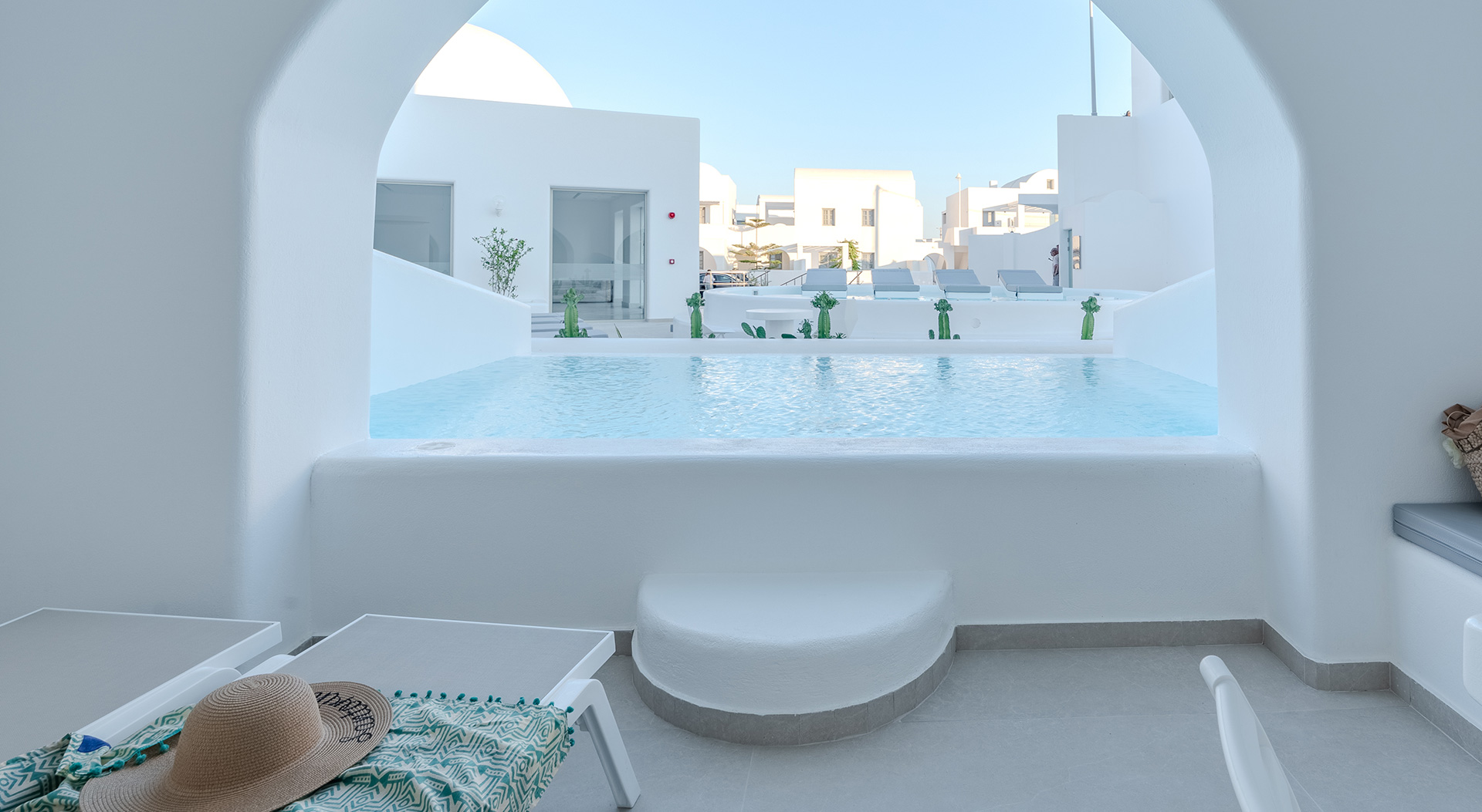 Arched view over the private pool from the terrace of the Signature Open Plan Suite at Antoperla Adults Only Santorini Hotel